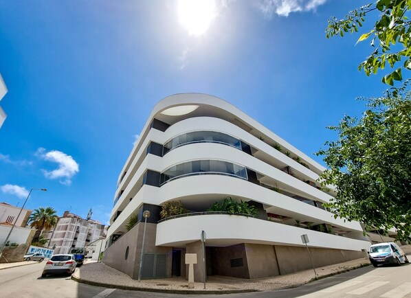 A multi-story building with balconies and a parking area. - FLH Lagos Central Flat with Terrace (Lagos)