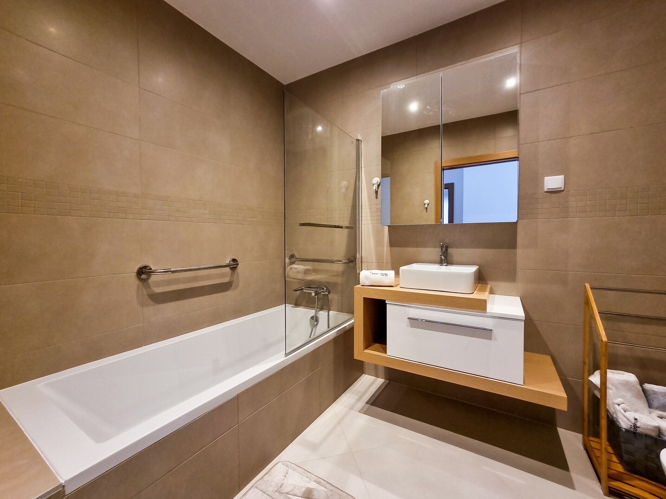 A modern bathroom with a bathtub, a vanity with a mirror, and a shower area.