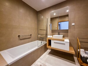 A modern bathroom with a bathtub, a vanity with a mirror, and a shower area. - FLH Lagos Central Flat with Terrace (Lagos)