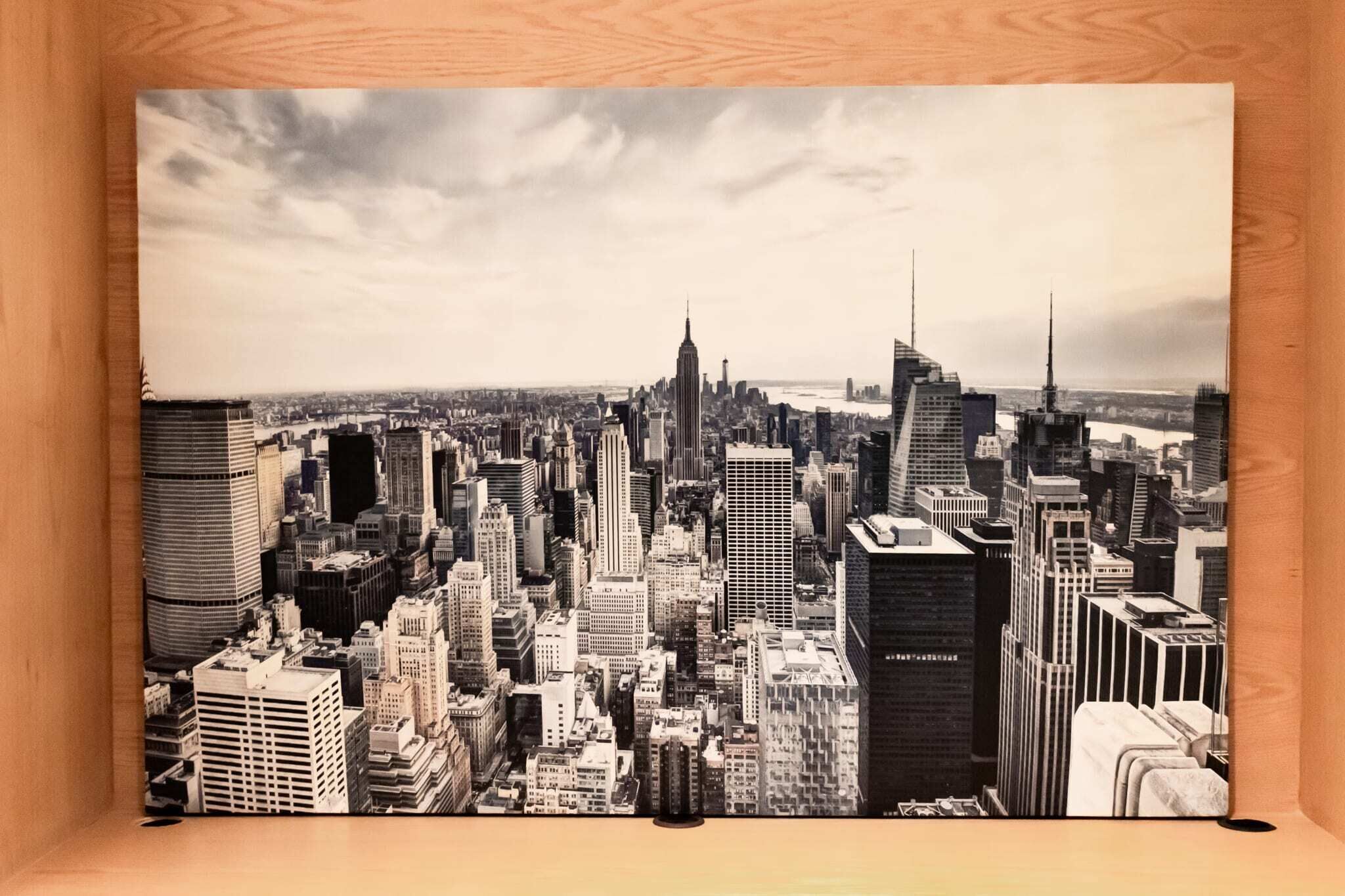 A black and white photograph of a cityscape with numerous high-rise buildings, including a prominent skyscraper in the center.