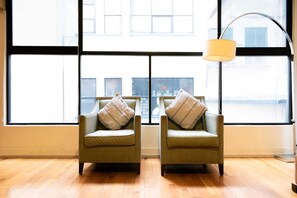 Two armchairs with cushions facing a large window with a view of buildings. - Amplio departamento en el Corazon de Colinia Roma (Ciudad de México)