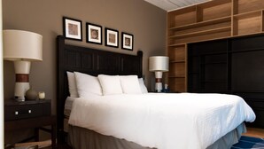 A neatly arranged bedroom with a large bed, dark wooden headboard, and a blue patterned rug. - Amplio departamento en el Corazon de Colinia Roma (Ciudad de México)