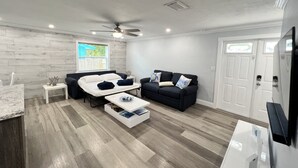 Un salon moderne avec un canapé, une table basse et un téléviseur.