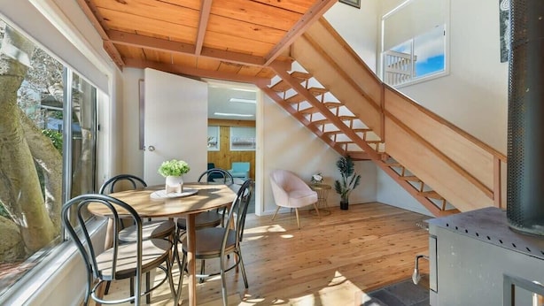 A wooden ceiling, a dining area with chairs, a staircase, and a wood-burning stove. - Collwood Cottage. Four Beds + Fireplace. Orange. (Orange)