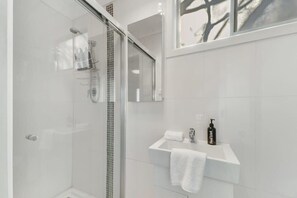 Een bad, een haardroger, handdoeken, shampoo