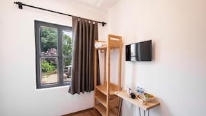 A room with a bunk bed, a TV mounted on the wall, a small table with a bottle and glasses, and a window with curtains. - Solo Boutique Hotel (Antalya)