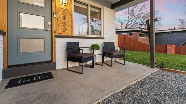 A front porch with two chairs, a small potted plant, and a wooden number display. - Sauna- Hot Tub- Garage Game Room- Outdoor Dining (Arvada)