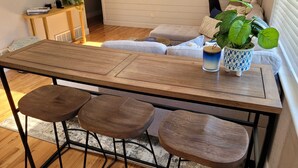 A dining area with a wooden table and three stools. - Sauna- Hot Tub- Garage Game Room- Outdoor Dining (Arvada)