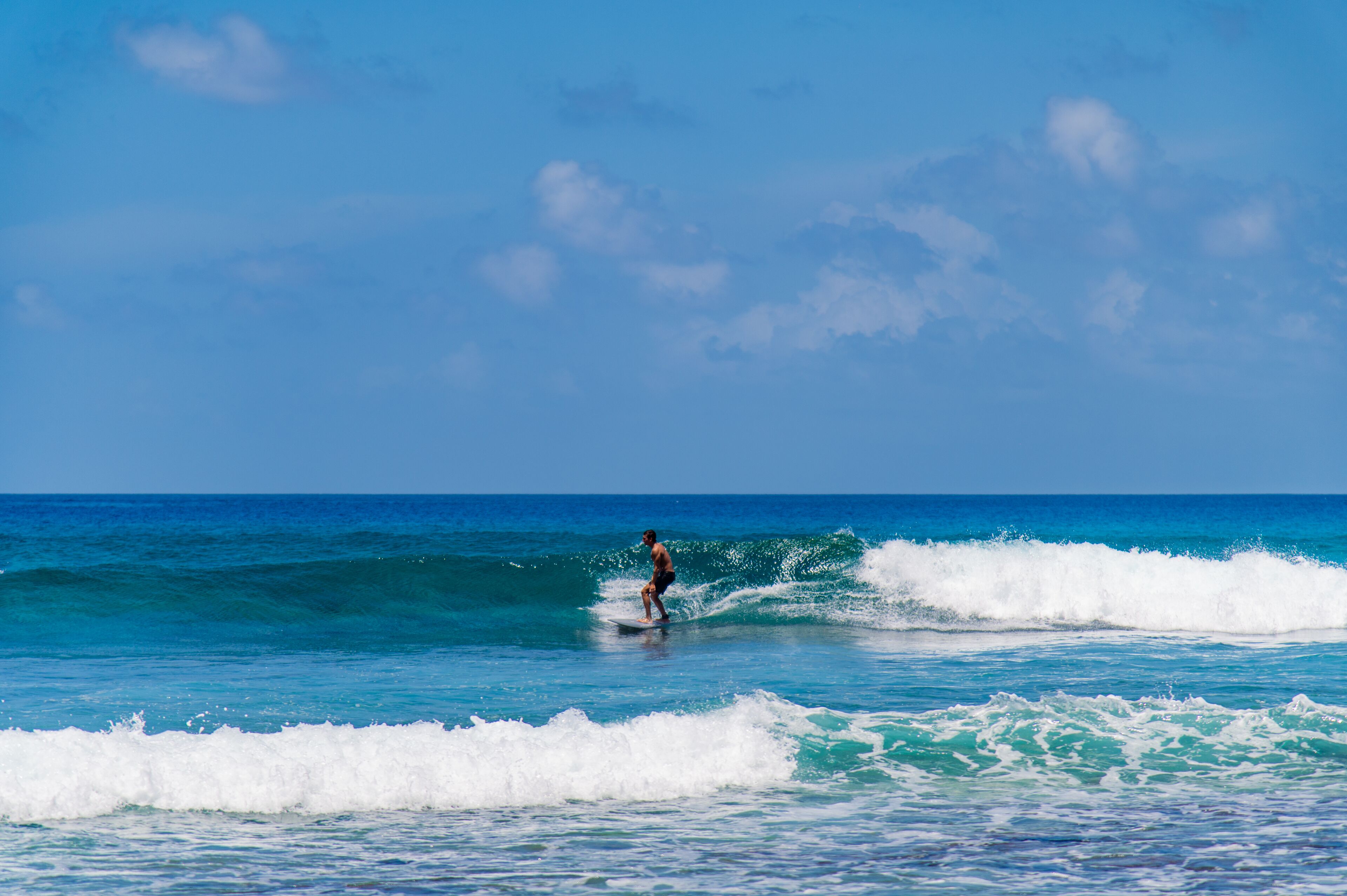 A person surfing on a wave in the ocean.