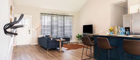 Un espacio habitable moderno con comedor, cocina y equipo de ejercicio.