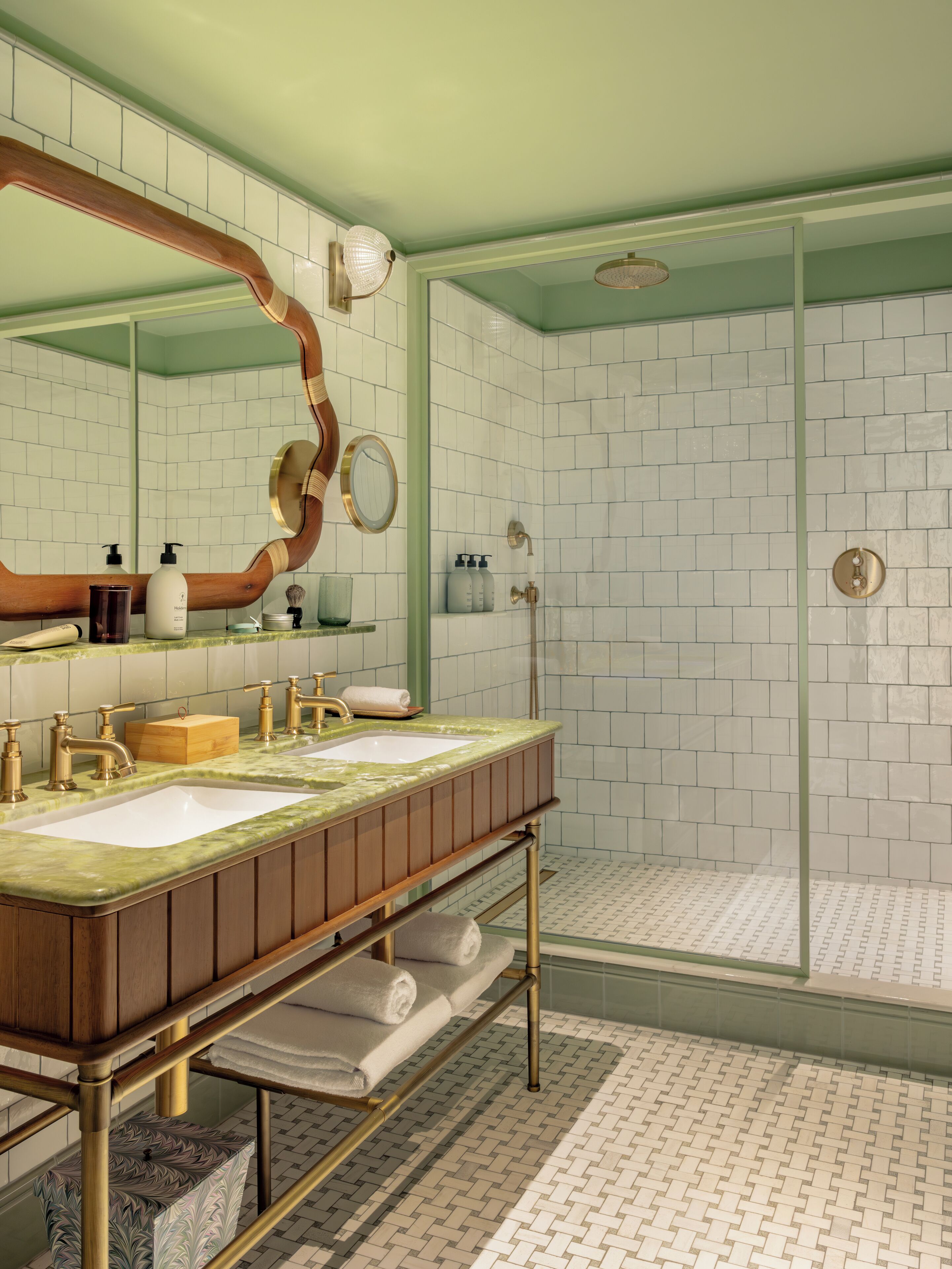 A bathroom with two sinks, a large mirror, and a shower area.