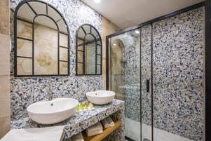Casa de banho com duas pias, um espelho e cabine de duche.