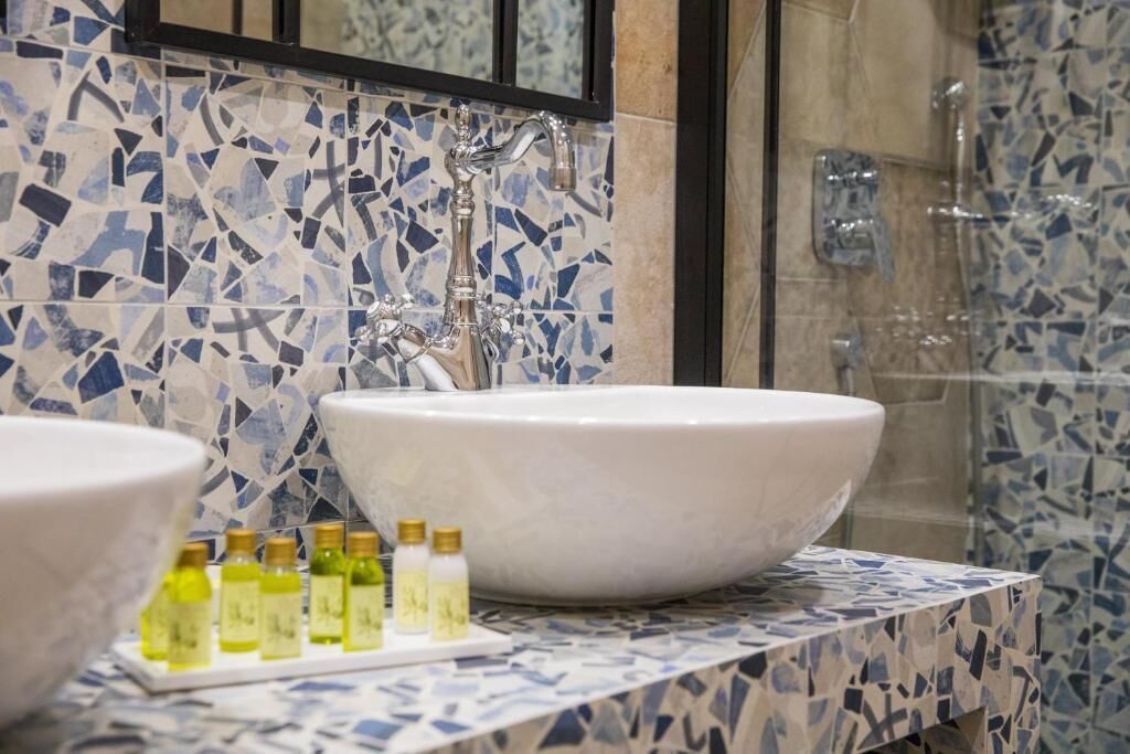 Un baño con un lavabo grande de color blanco, un espejo y zona de ducha.