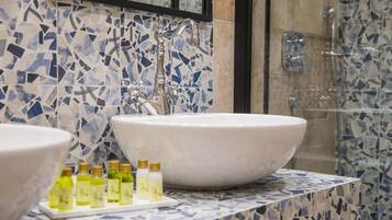 Un baño con un lavabo grande de color blanco, un espejo y zona de ducha.