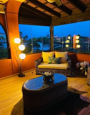 Relax on the balcony with a wicker sofa and coffee table, taking in the views of the surrounding area.