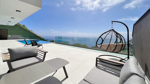 Eine Dachterrasse mit Pool, Sitzgelegenheiten im Freien und einer Hängematte.