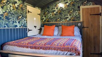 Una habitación con una cama, un armario de madera y una puerta decorada con un estampado de jungla.