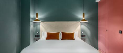 A modern bedroom with a large bed, two bedside tables, and a red wardrobe.