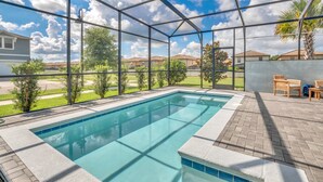 A swimming pool with a clear view of the sky and surrounding houses. - Headline (Kissimmee)