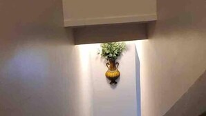 Un escalier orné d’un vase décoratif et d’un mur à motifs à sa base.