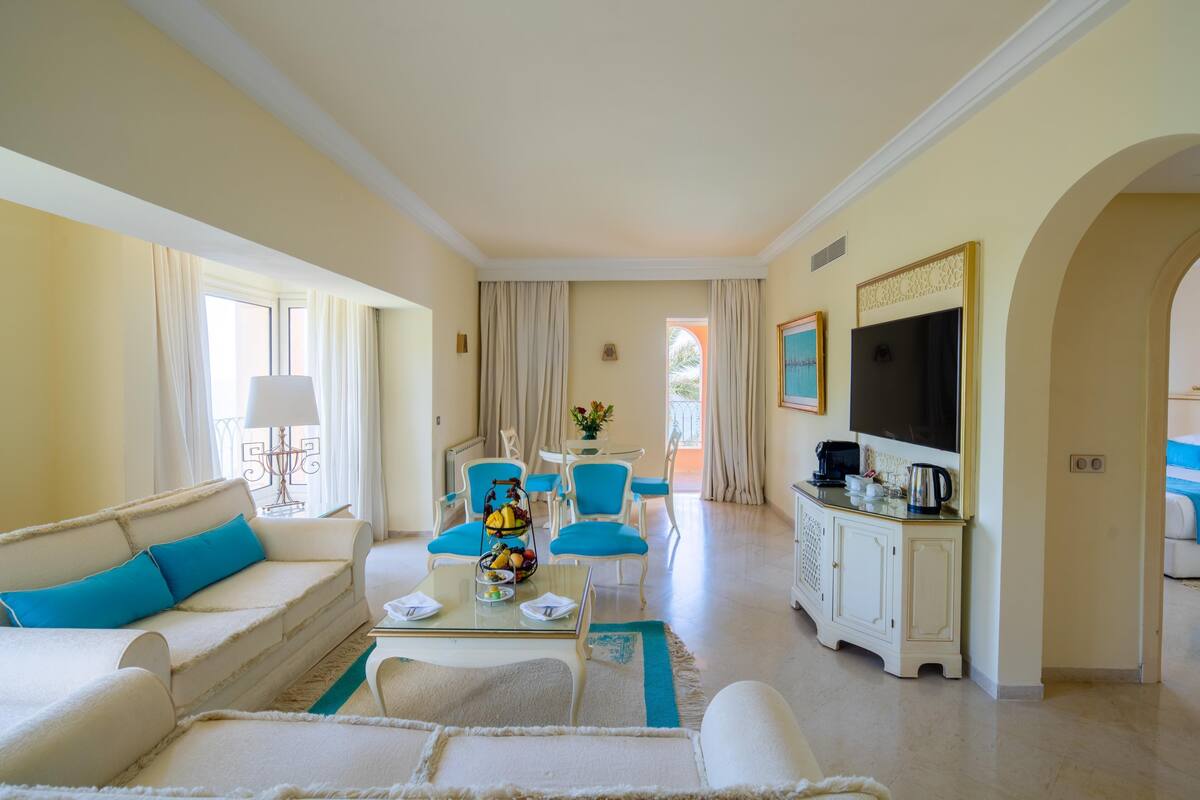 A spacious living room with a sofa, chairs, a coffee table, and a television.