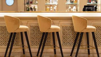 A bar area with three bar stools and a bar counter.