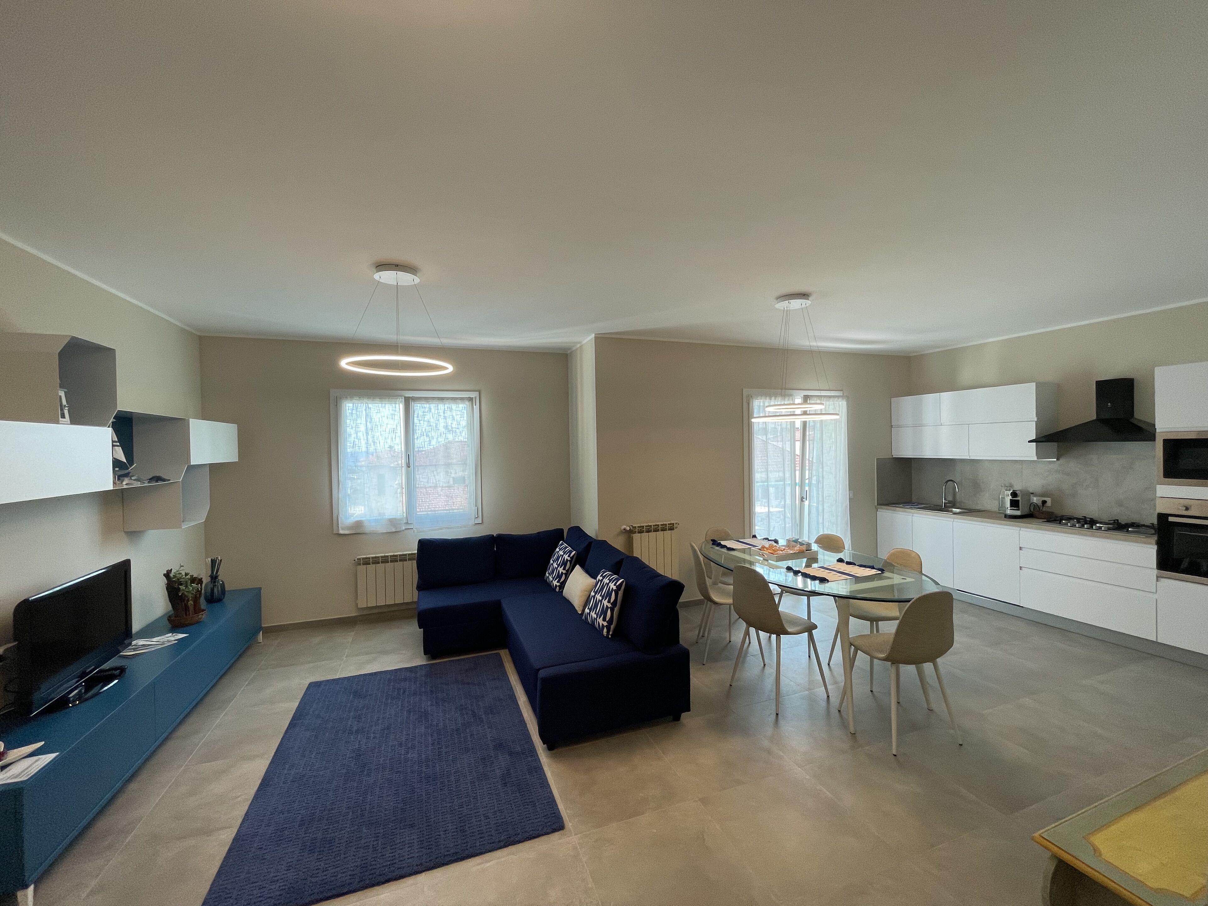 Un espacio habitable moderno con sofá, mesa de comedor y área de cocina.
