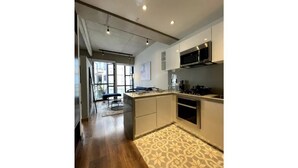Una cocina moderna con una isla central, electrodomésticos integrados y una alfombra estampada.