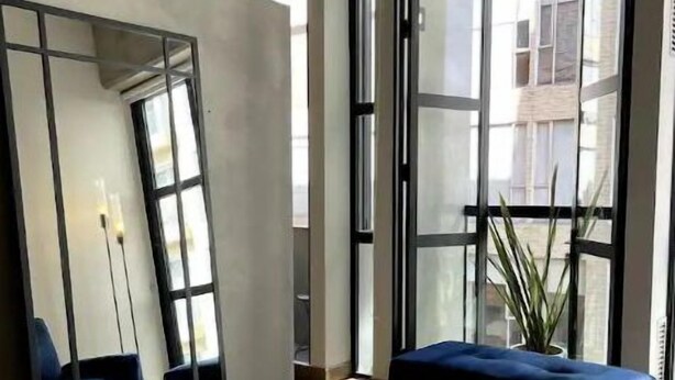 Una habitación moderna con un separador de vidrio, una mesa redonda y asientos azules.