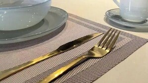 Una cocina moderna con encimera blanca, un bol de vidrio, una copa de vino y una taza de café.