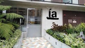 Una entrada de edificio con un diseño moderno, que presenta un puerta de vidrio y un letrero con la letra 'á'.