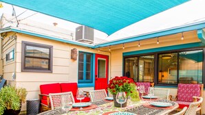 An outdoor patio with a round table set for dining, surrounded by wicker chairs. - Sunny Historic Cottage+Wineries+Outdoor Living+Verde Train+Holiday Availability (Clarkdale)
