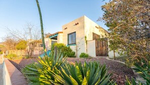 A modern house with a flat roof, large windows, and a well-maintained garden with agave plants. - Sunny Historic Cottage+Wineries+Outdoor Living+Verde Train+Holiday Availability (Clarkdale)