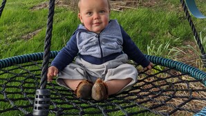 A child sitting on a rope swing attached to a tree. - Beautiful French Inspired Country Home Super Private River Views (Gambier)
