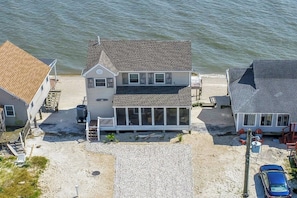 Ein zweistöckiges Haus mit Balkon, Garage und Auffahrt zum Strand.