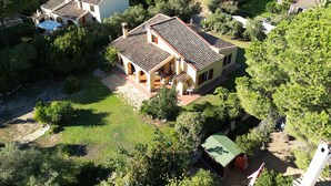 Uma propriedade residencial com telhado cerâmico, piscina e um jardim bem cuidado.
