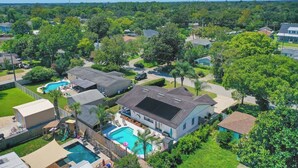 A residential area with houses, a swimming pool, and a large tree.