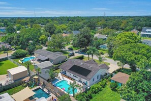 Zona residencial con casas, piscina y un árbol grande.
