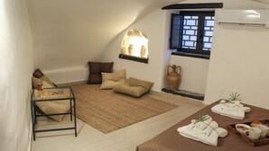 A cozy living room with a sofa, a coffee table, a rug, a window with a view, and a small table with towels and a tray. - Cozy apartment in the heart of the historic center of Palermo (Palermo)