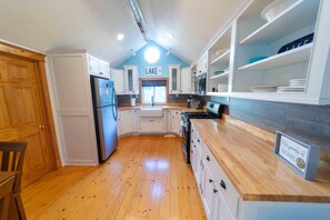 A kitchen with white cabinets, a wooden countertop, and a sign that says "LAKE."