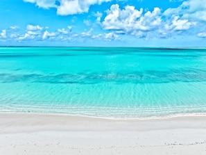 A beach with clear turquoise water and a white sandy shore.