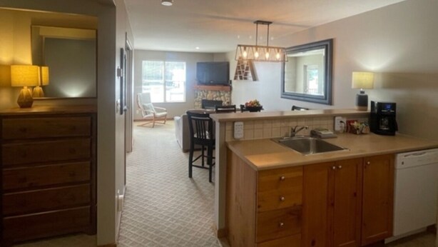A modern kitchen with wooden cabinets, a built-in island, and a large window. - Creekside condo w/full kitchen, gas fireplace, close to trails & village (Silver Star Mountain)