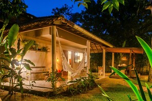A house with a covered porch, a hammock, and potted plants. - CASA BIRIBIRI TRANCOSO (Porto Seguro)