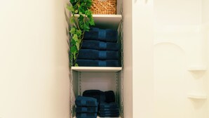 A narrow walk-in closet with shelves holding folded towels and wicker baskets. - COZY, BEAUTIFUL APARTMENT AT AVANTI COVE (Conneaut Lake)