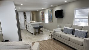 Un salon moderne avec un canapé, une table basse et un téléviseur fixé au mur.