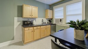 Una cocina con armarios de madera, microondas y pileta.