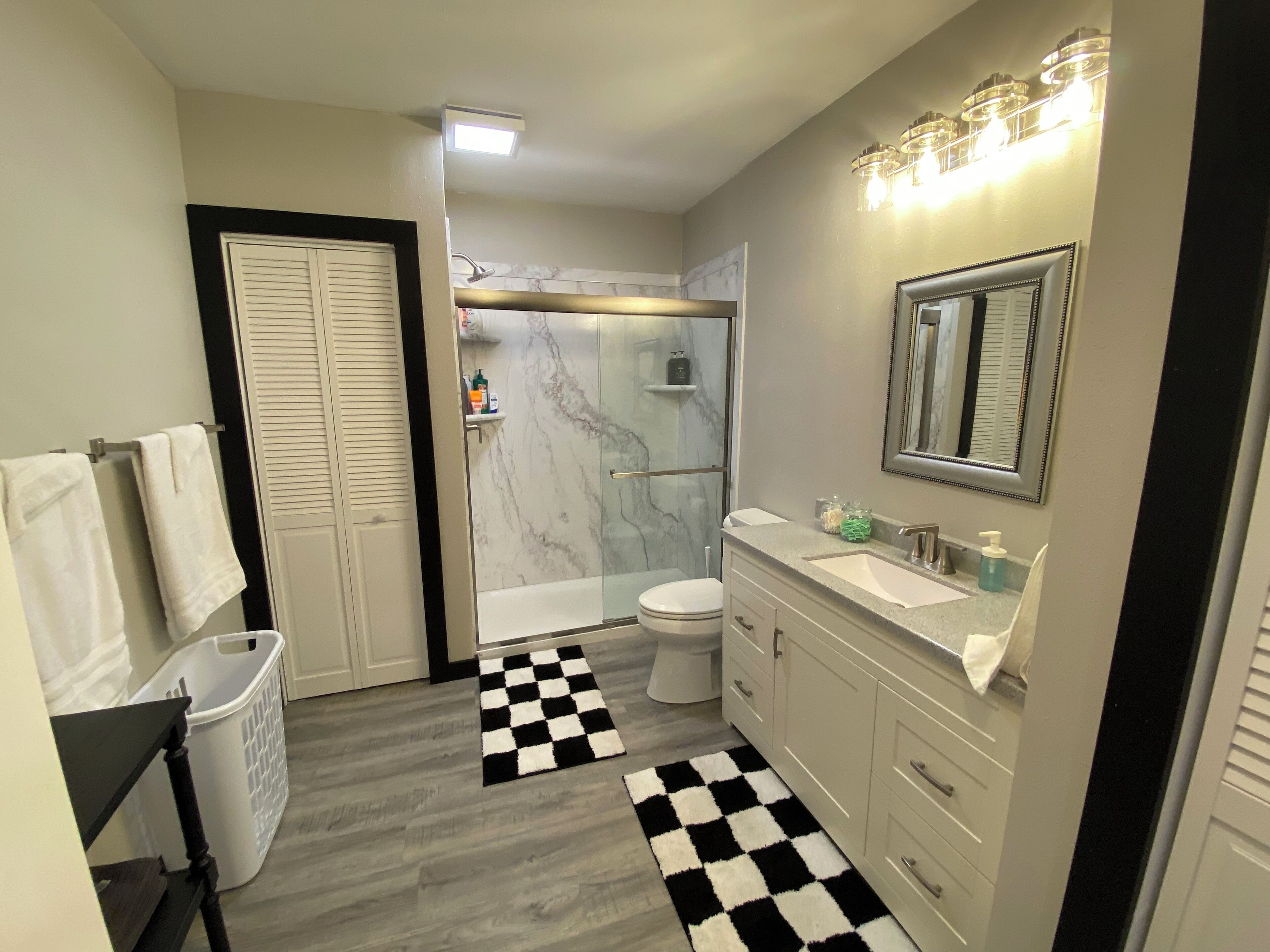 Une salle de bain moderne équipée d’une douche, de toilettes et d’un meuble-lavabo.