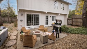 A backyard with a barbecue grill, wicker furniture, and a hot tub. - Black Oak by Avantstay Modern & Chic Santa Rosa Hideaway With Pool Table, & Fire Pit (Santa Rosa)