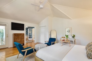A bedroom with a bed, a desk, a chair, a mirror, and a television. - Crawdad by Avantstay Isle of Palms Home w/ BBQ (Isle of Palms)