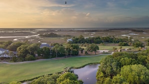 A golf course with a pond, trees, and houses in the background. - Crawdad by Avantstay Isle of Palms Home w/ BBQ (Isle of Palms)